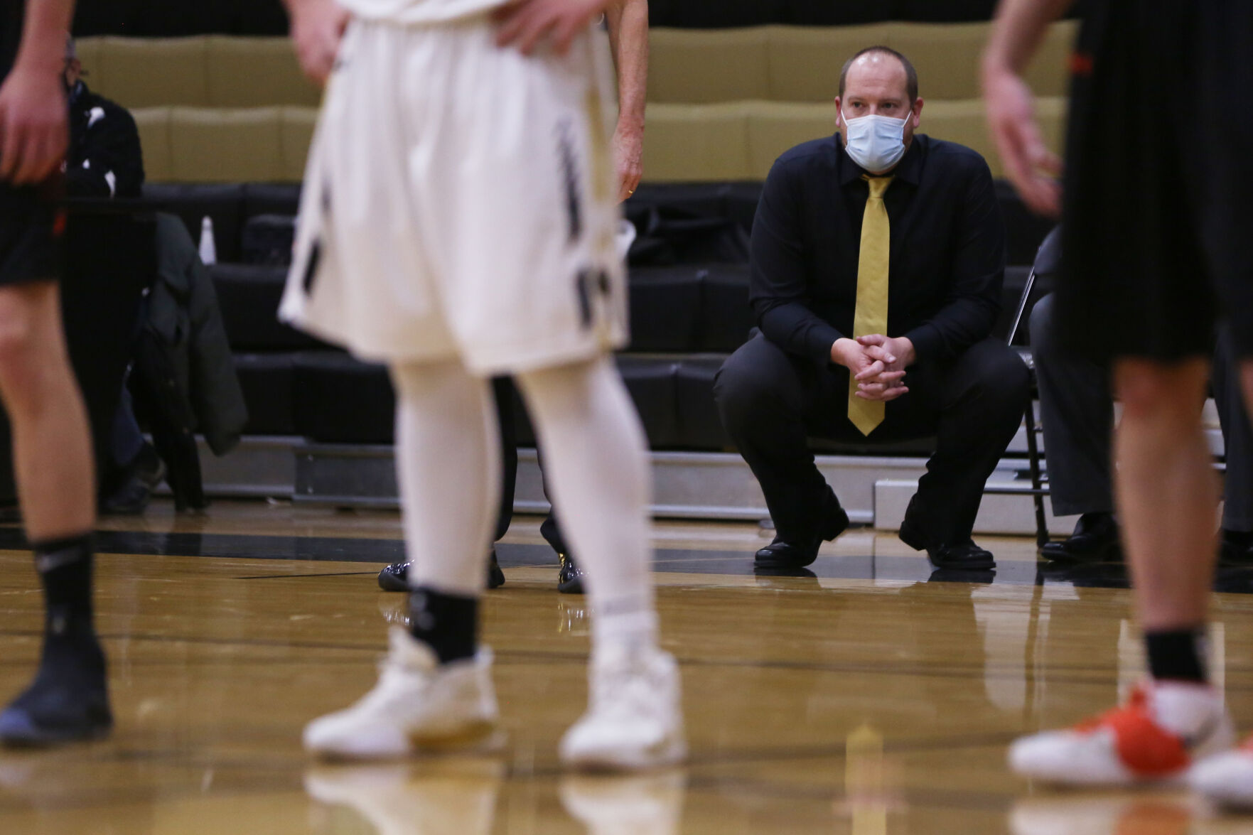 Tanner Hart kneels from the edge of the bench